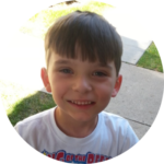 Young boy smiling outdoors supported by nonprofit