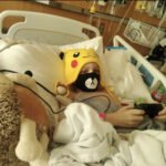 Child in hospital bed with teddy bear supported by Give Hope Nevada